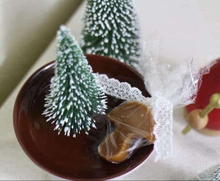 Verpackt in Folie und mit einem Spitzenband verschnürt sind die weihnachtlichen Karamellbonbons das perfekte Geschenk
